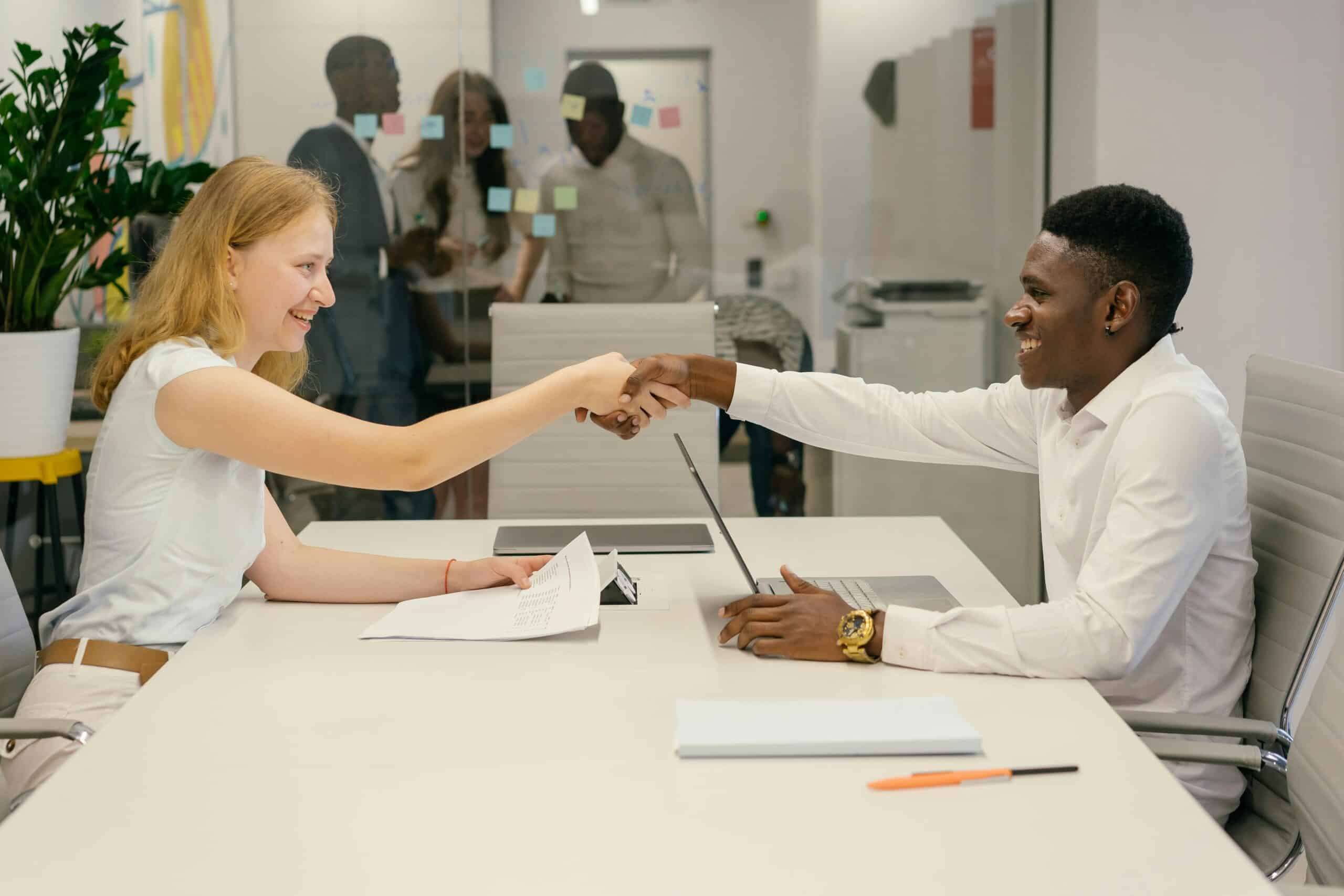 Blog 9 Free Business professionals completing a successful deal with a handshake in a modern office setting. Stock Photo